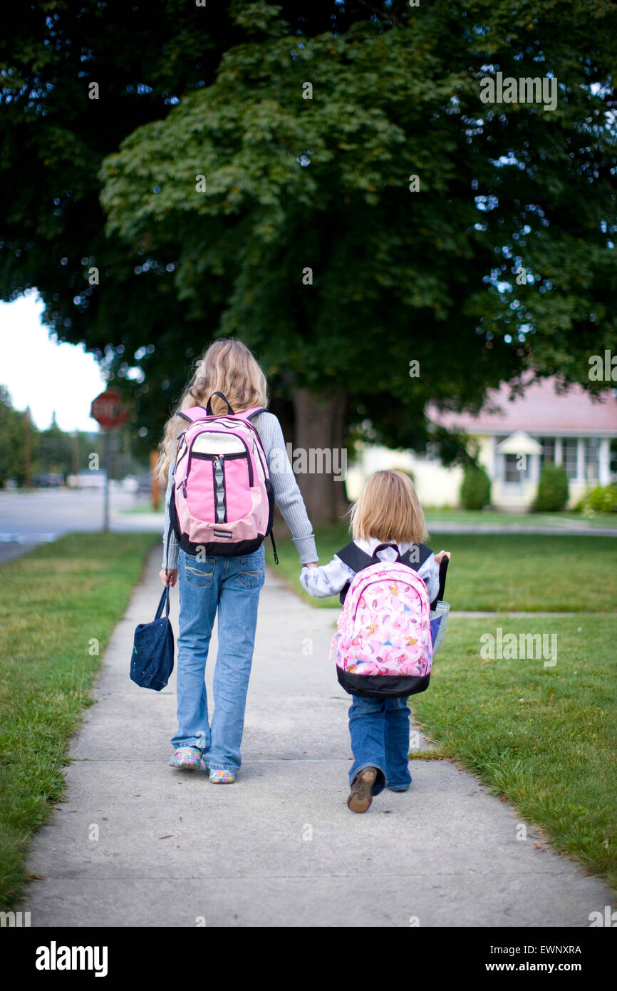 Two friends walking to school on the first day of class Stock Photo