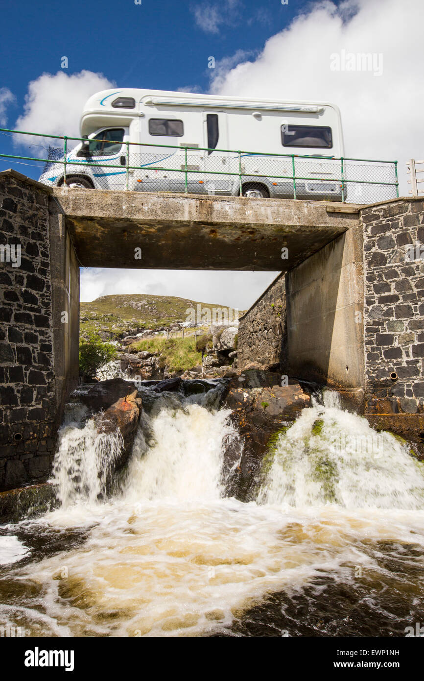 A camper van crossing a bridge over the Abhainn Eadarra amongst rugged mountain scenery on North East Harris, Outer Hebrides, Scotland, UK. Stock Photo