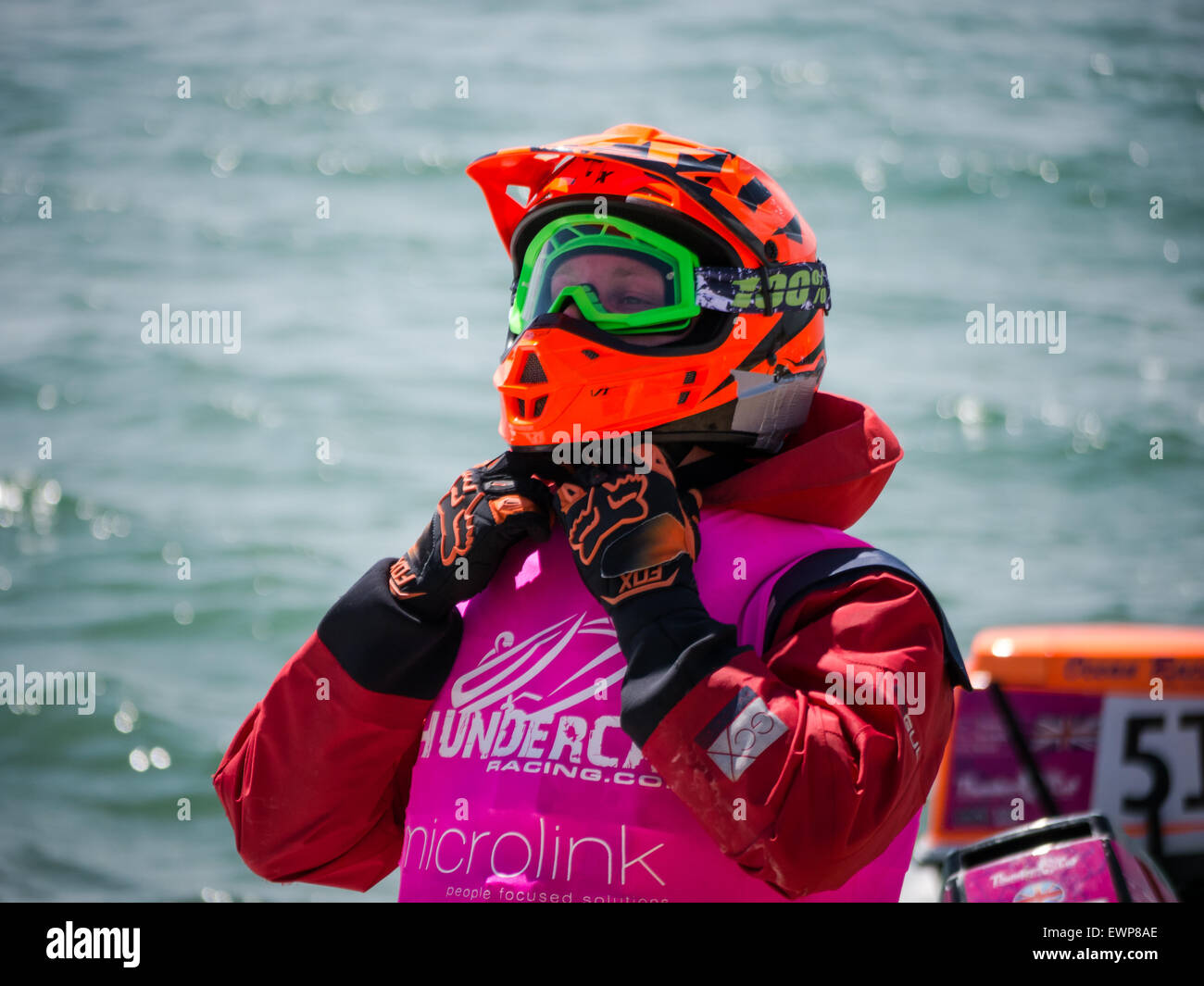 A powerboat coxswain fastens his safety helmet prior to a thundercat RIB race Stock Photo