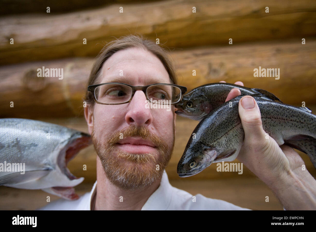 a Chef poses for a silly portrait with some Fish. Stock Photo