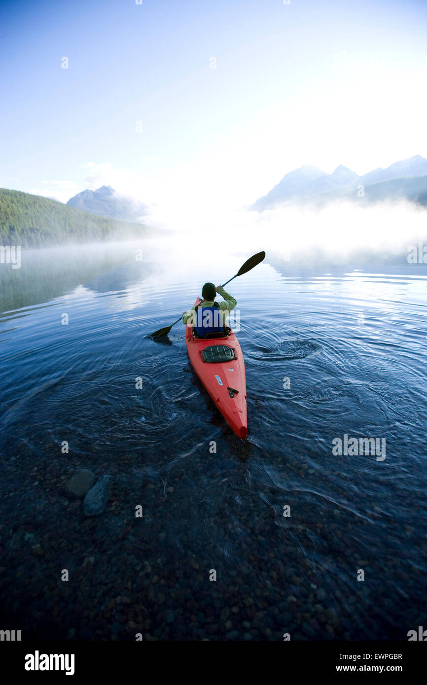 Man paddles alone on a mountain lake. Stock Photo