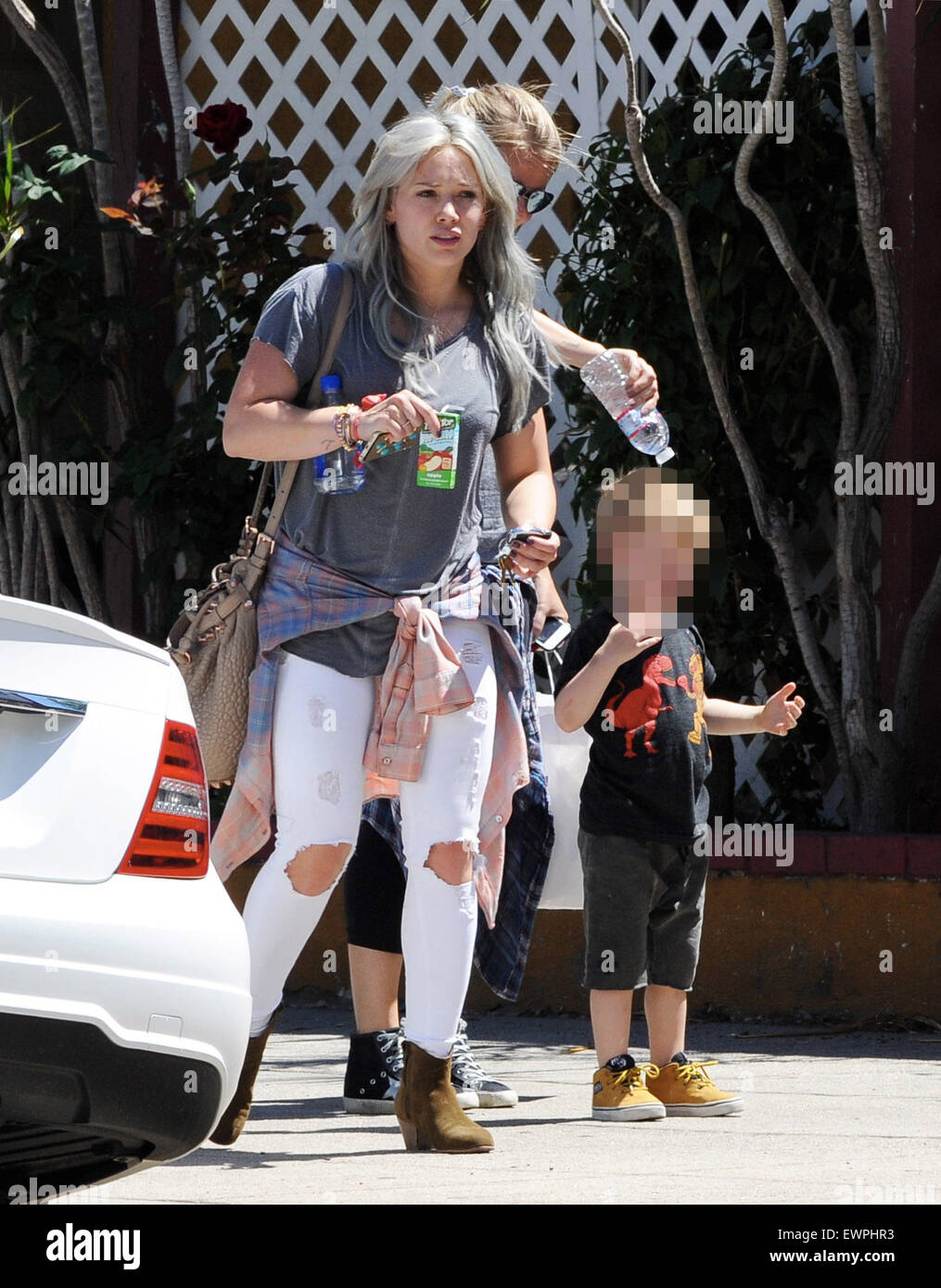 Hilary Duff still sporting her dyed hair, takes her son Luca to The Co-op in Studio City as he was cooled down on a hot spring day, getting sprinkled with bottled water by his nanny  Featuring: Hilary Duff, Luca Comrie Where: Los Angeles, California, United States When: 28 Apr 2015 C Stock Photo