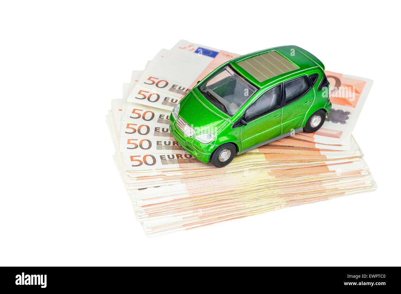 Green model car on stack of euro notes as symbol for buying or costs Stock Photo