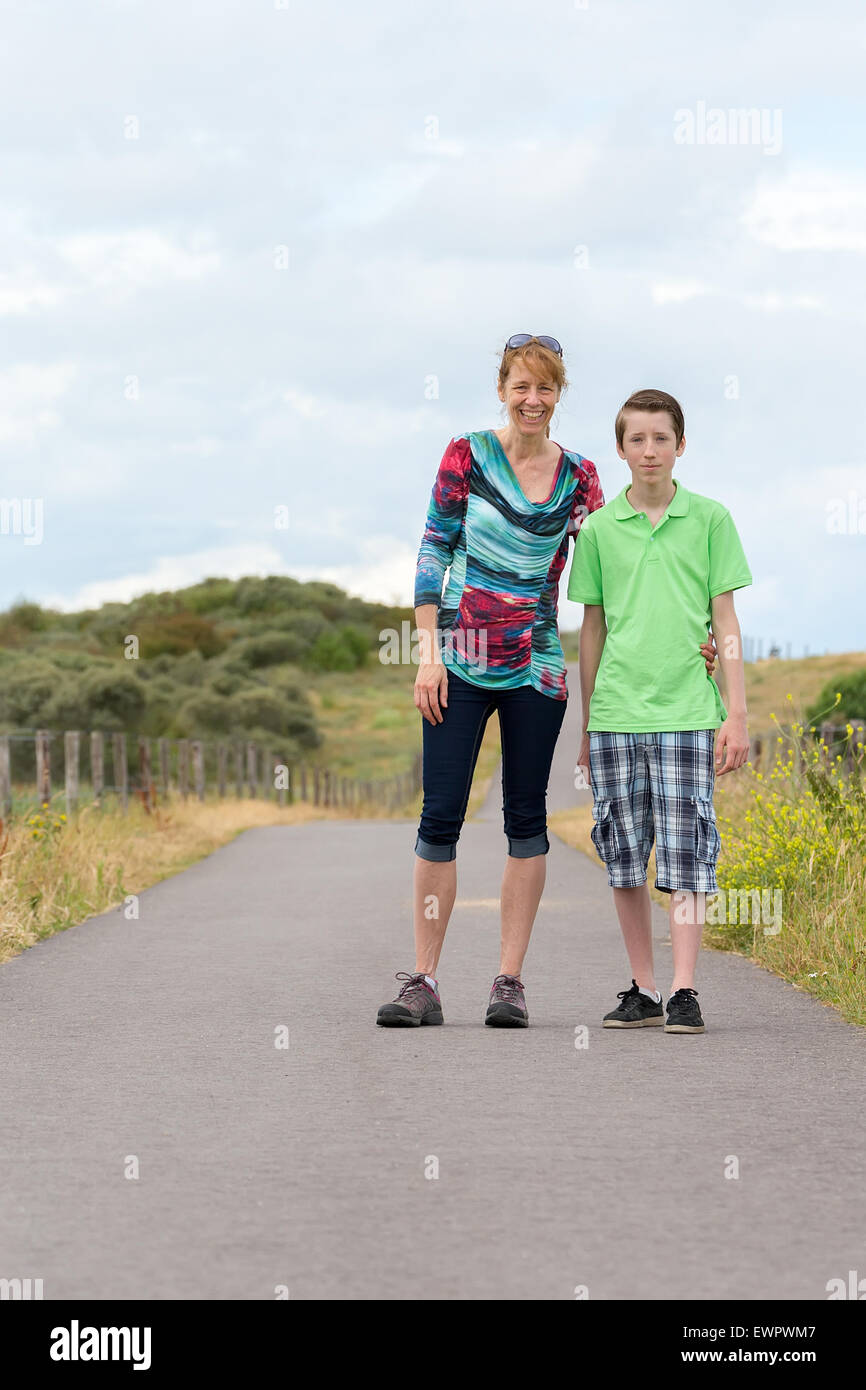 Caucasian mother and son hiking on footpath in nature Stock Photo