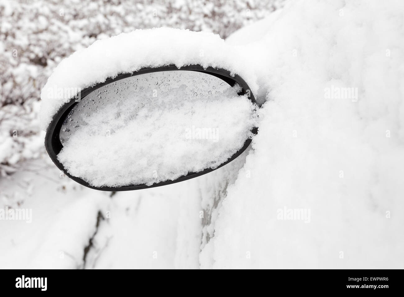 Car mirror filled with snow in winter season Stock Photo