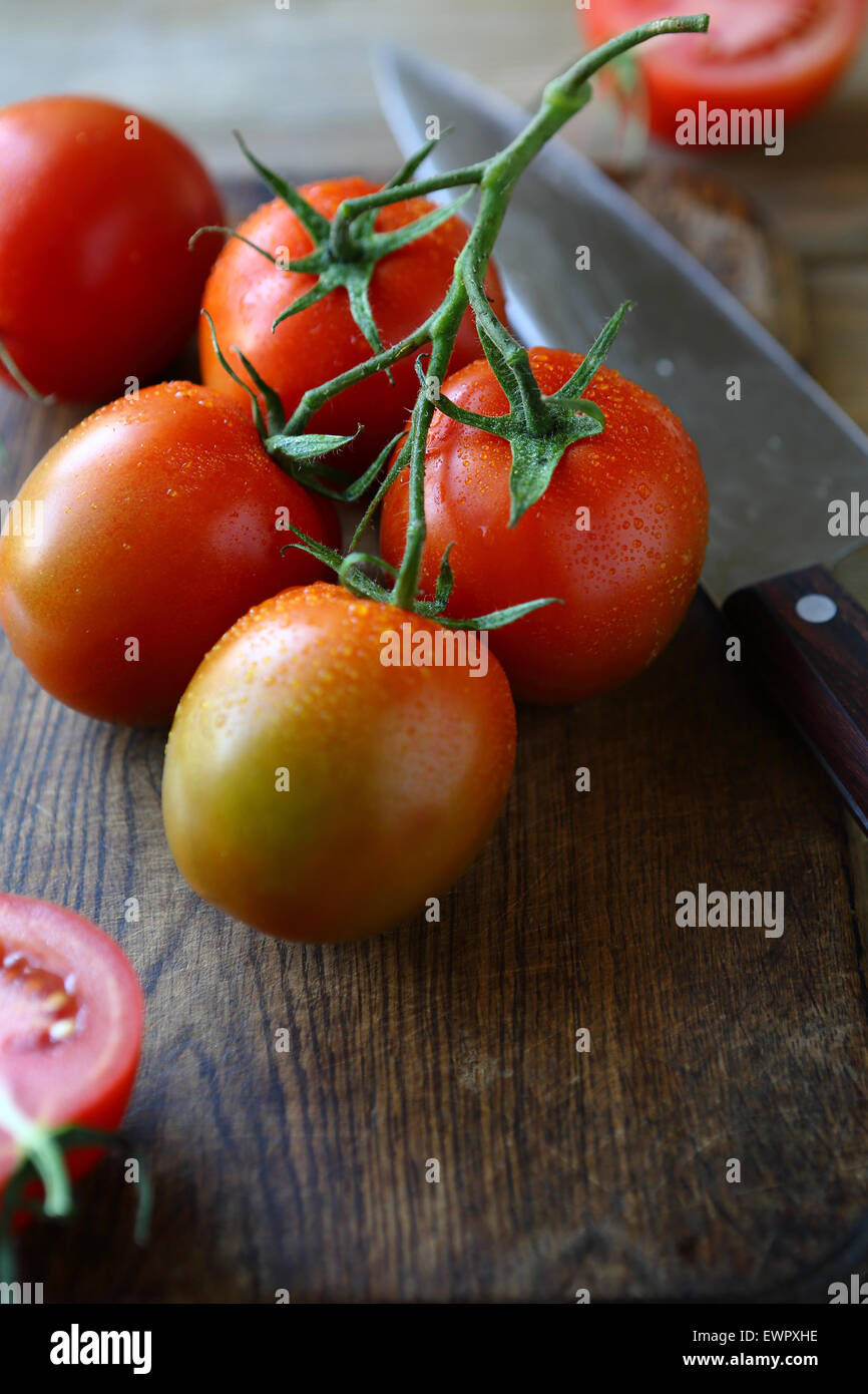 fresh tomatoes on the old board, cooking Stock Photo - Alamy