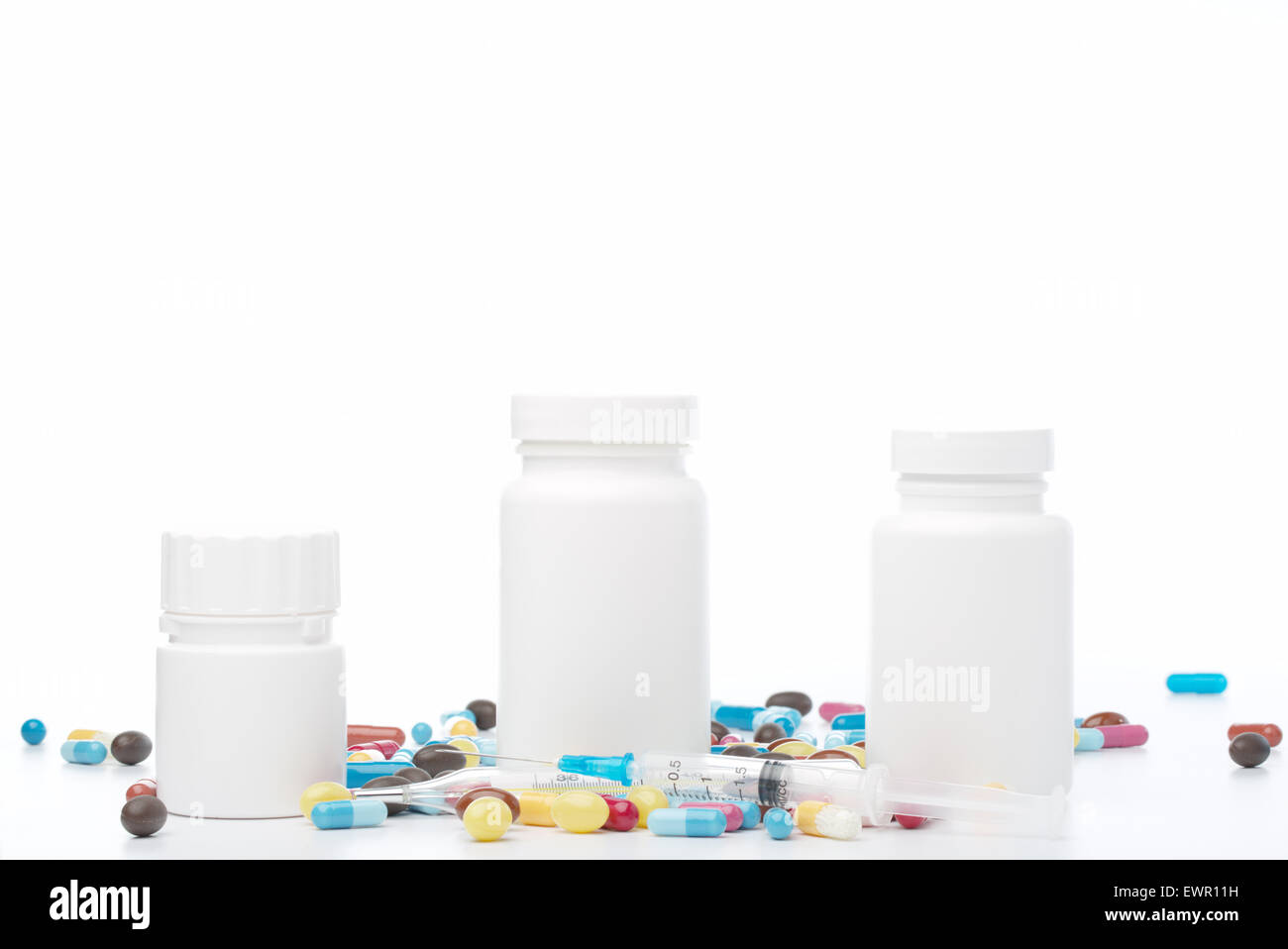 White plastic pill bottle and colorful pills on white background Stock Photo