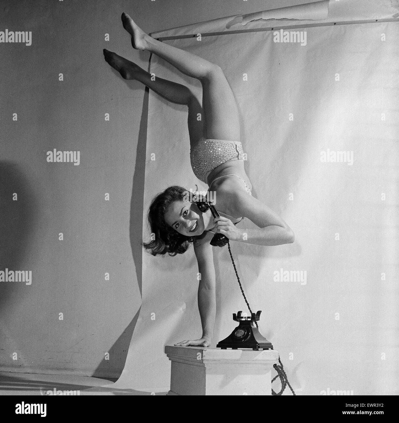 18 year old Eleanor Gunter is an equilibrist, an acrobat who performs balancing feats. Balancing on one hand using a telephone. She's in the UK to appear at the Glasgow Empire theatre, 1st September 1957. Stock Photo