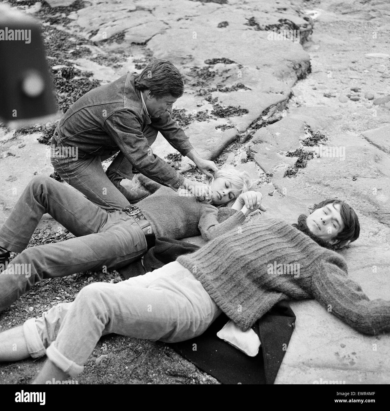 French actress Brigitte Bardot on location in Scotland during filming of her latest movie 'Two Weeks in September' with leading man Laurent Terzieff.  Here they are pictured lying on the rocks at Seacliffe during a scene from the film. September 1966. Stock Photo