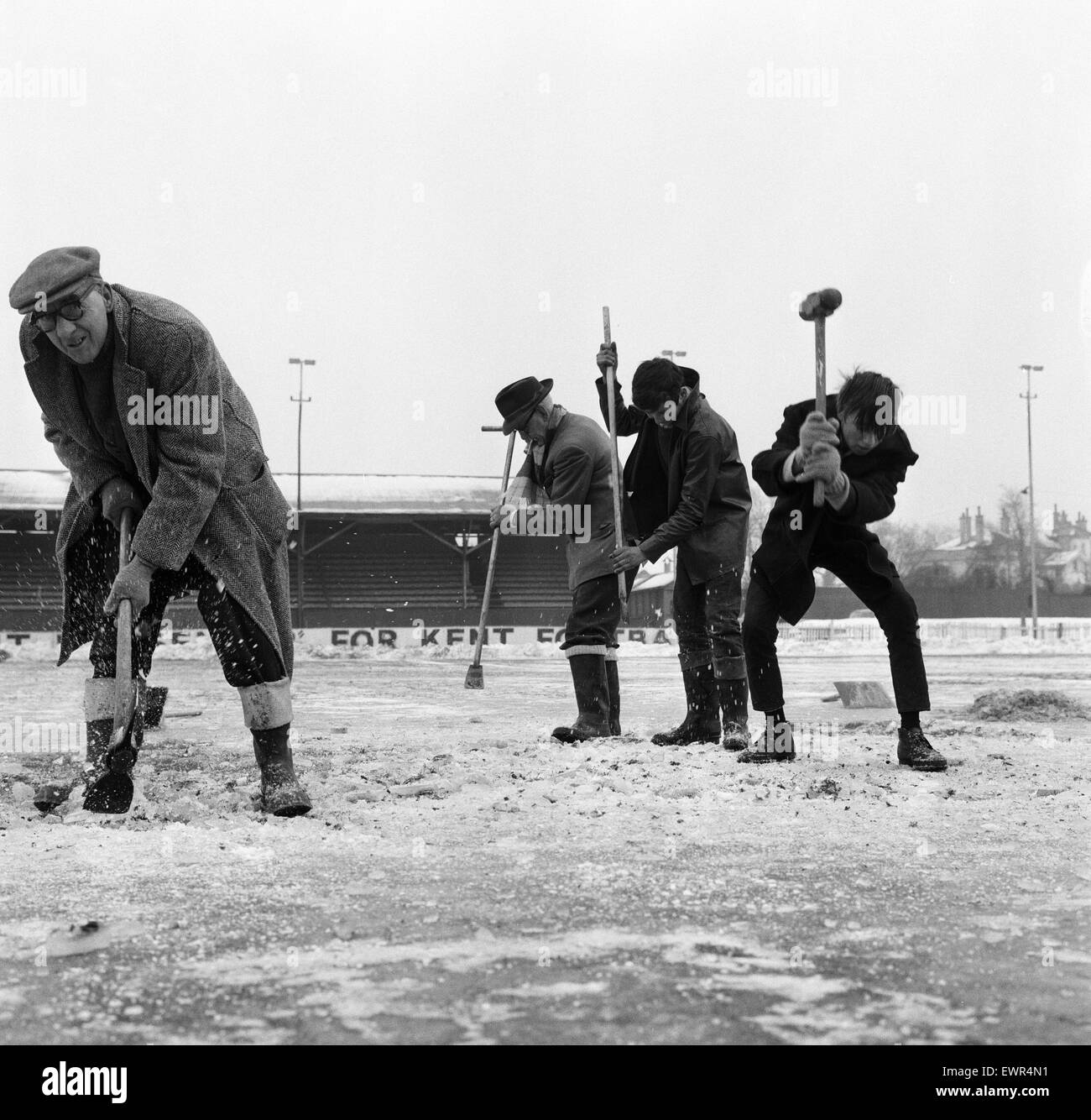 Gravesend and  Northfleet  training session in the snow ahead of their FA Cup fourth round match against Sunderland. Pictured are workmen trying to crack the ice on the Gravesend pitch in preparation for the match. 7th February 1963. Stock Photo