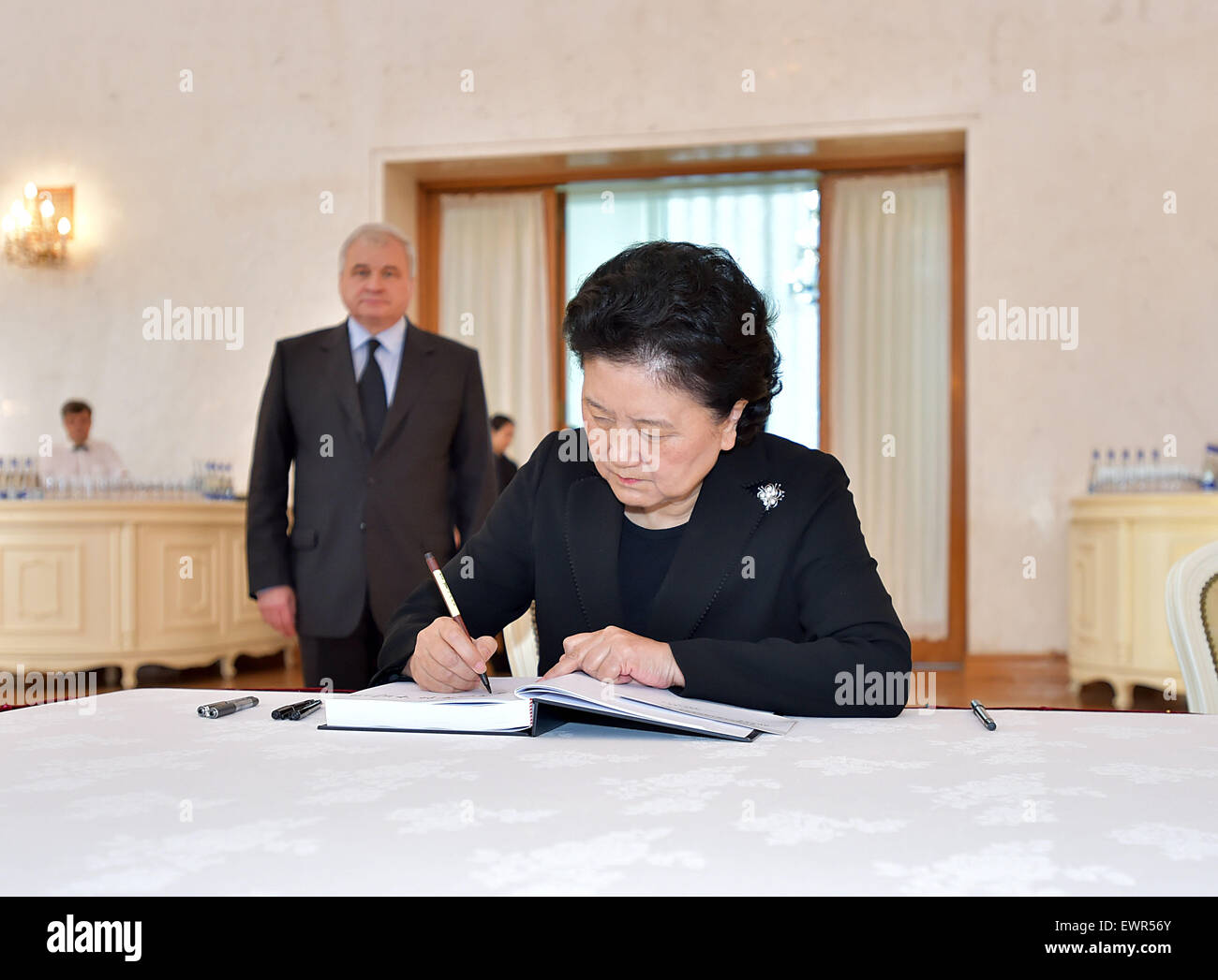 Beijing, China. 30th June, 2015. Chinese Vice Premier Liu Yandong (front) signs on a condolence book during a ceremony to mourn the passing of former Russian Prime Minister Yevgeny Primakov at the Russian embassy in Beijing, capital of China, June 30, 2015. © Li Tao/Xinhua/Alamy Live News Stock Photo