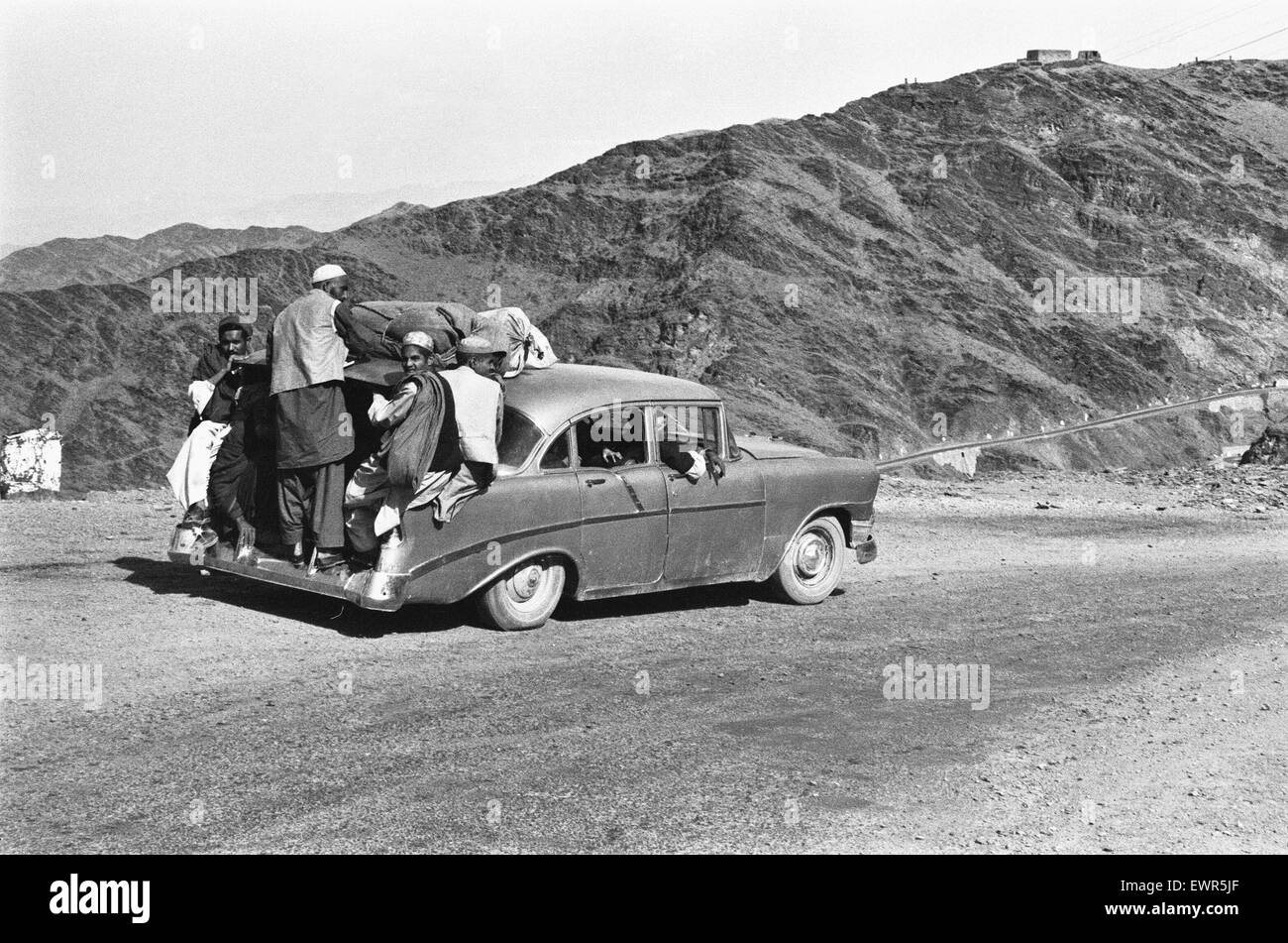 Khyber Pass taxi service. One of the strangest taxi services in the world. Up to 14 people cram into and outside of old American Chevrolet cars . April 1977 Stock Photo
