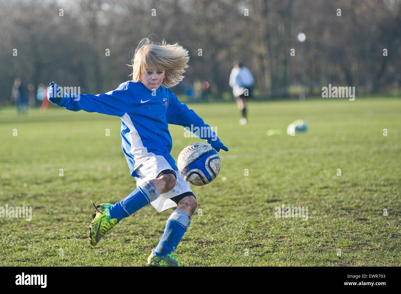 A young boy plays football in London for his local team Stock Photo Alamy