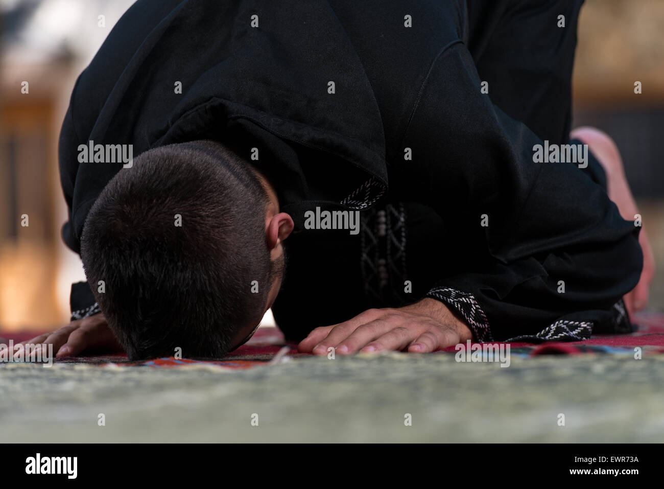 Young Muslim Man Making Traditional Prayer To God While Wearing A Traditional Cap Dishdasha