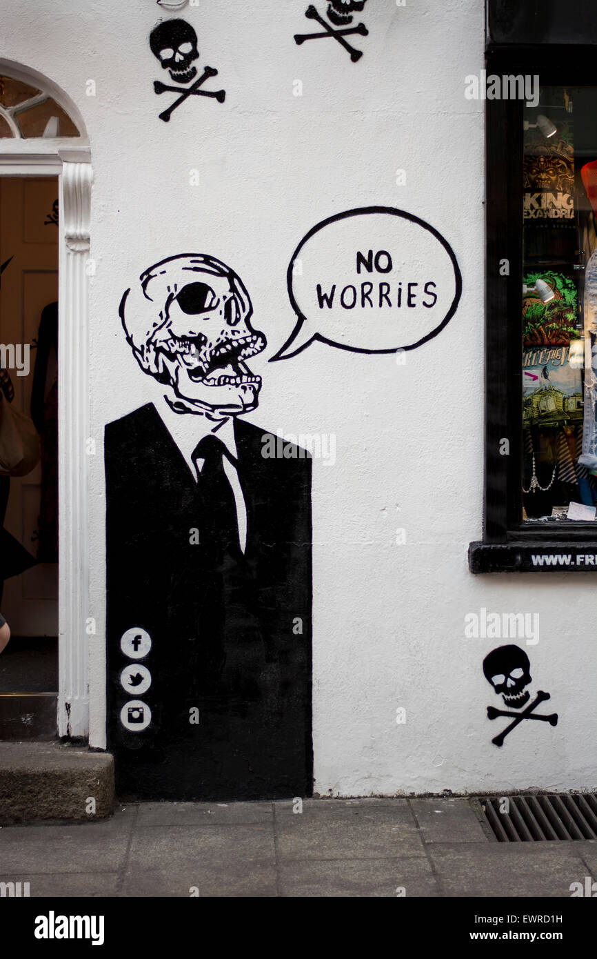 Graffiti artwork of a Skull in a suit with speech bubble 'no Worries' on a wall on a wall in Temple bar, Dublin Stock Photo