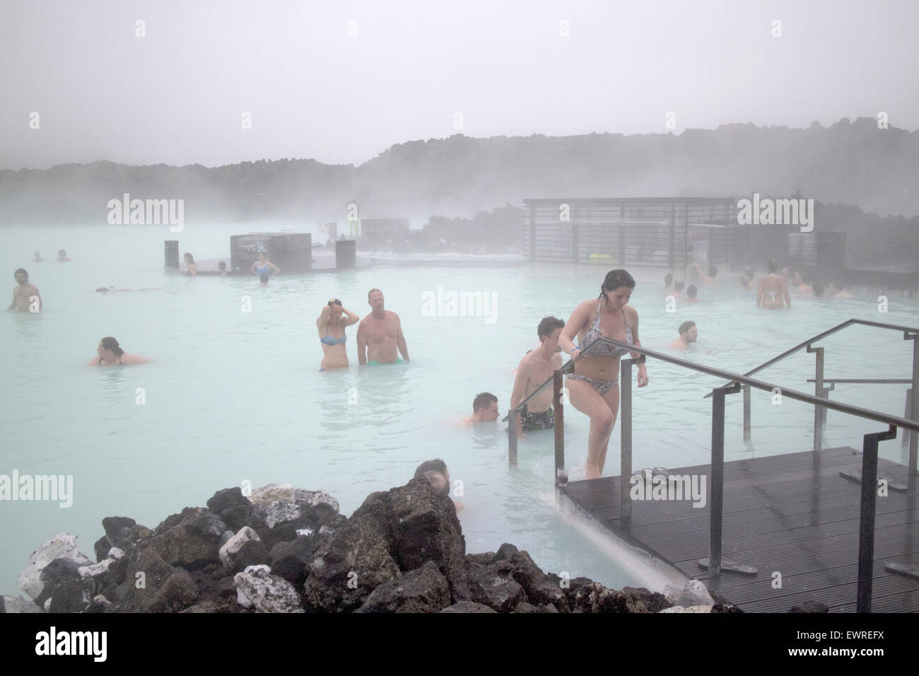 tourists at the blue lagoon spa in misty cold weather Iceland Stock Photo