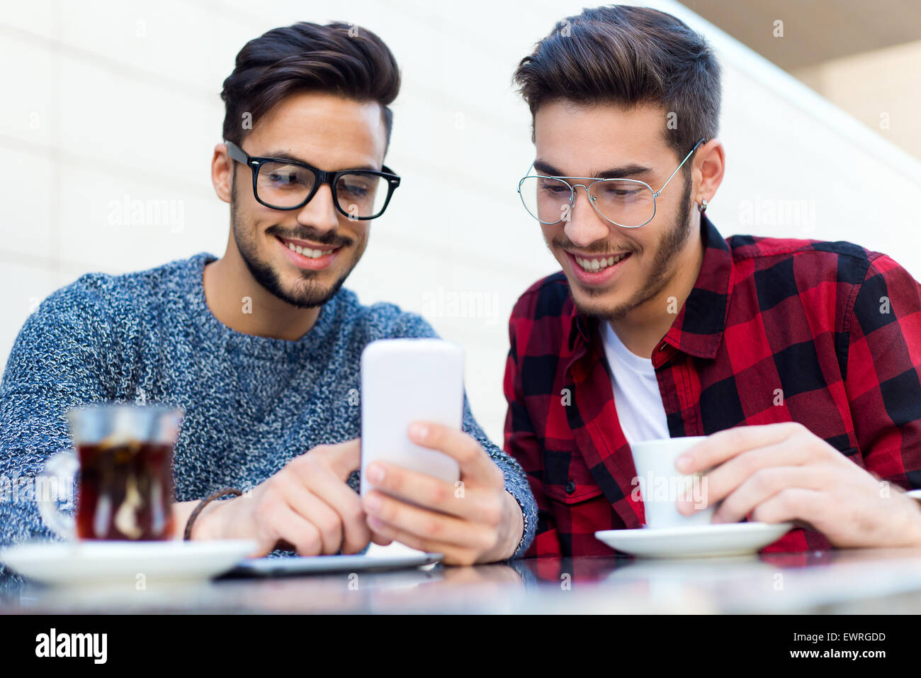 Outdoor portrait of two young entrepreneurs working at coffee shop. Stock Photo