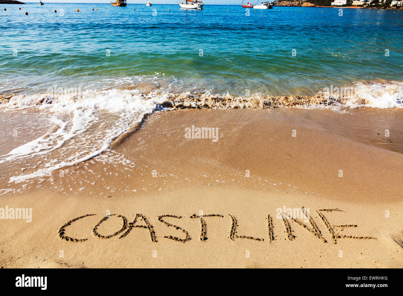 Coastline word in sand written on beach Spanish fun resort seas coast