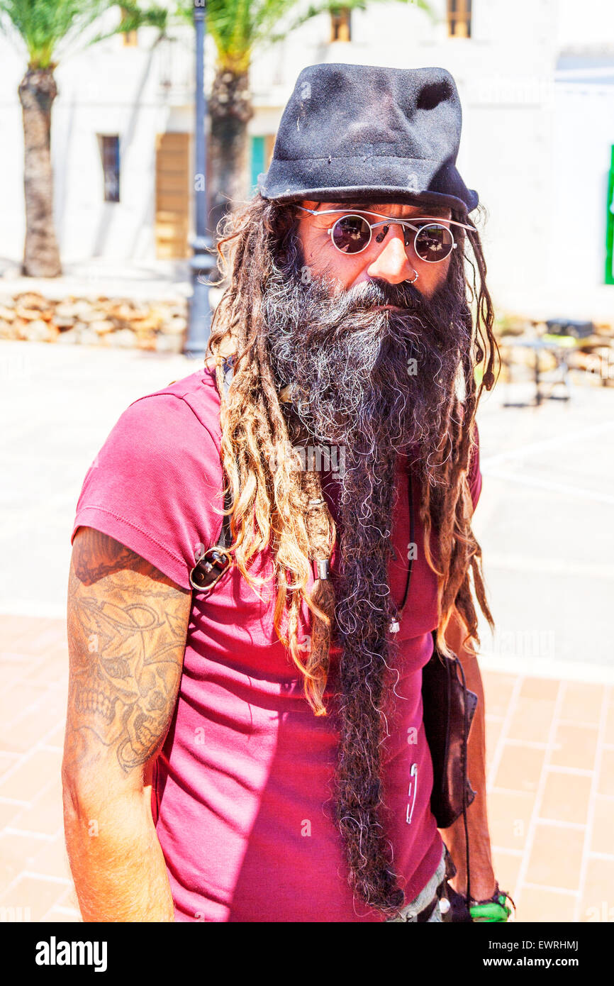 Hippy dreadlocks beard hat glasses tattoos mean looking man Ibiza Spain Spanish resort Stock Photo