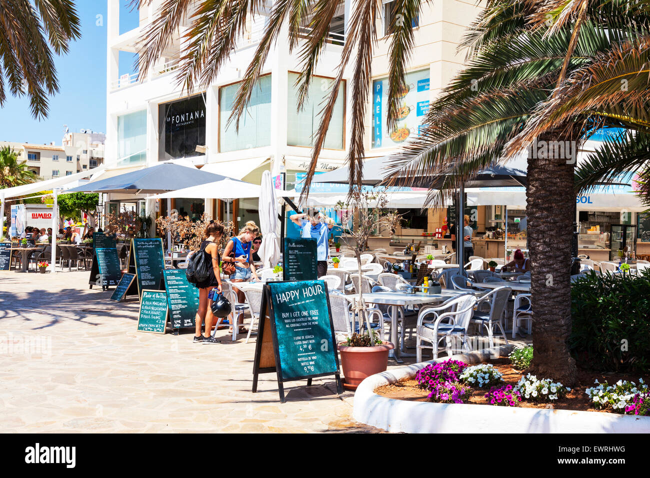 Girls looking at menu cafe restaurant Santa Eulalia Del Rio Spain Spanish resort Stock