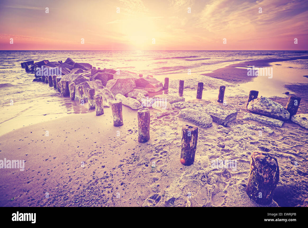 Retro vintage style beautiful sunset over Baltic Sea coast with lens flare effect, Miedzyzdroje in Poland. Stock Photo