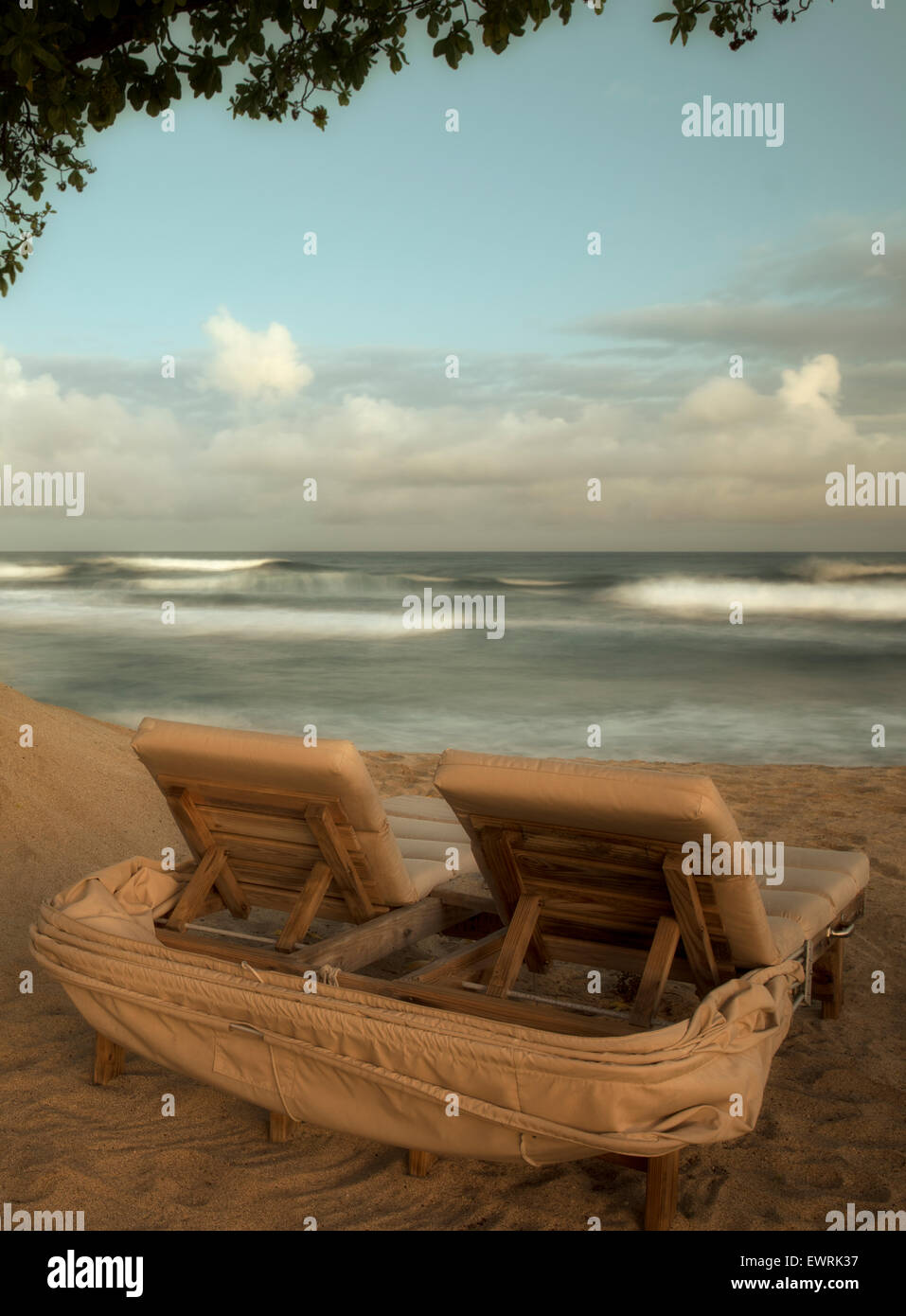 Moon setting over ocean with beach chairs. Hawaii, The big Island Stock