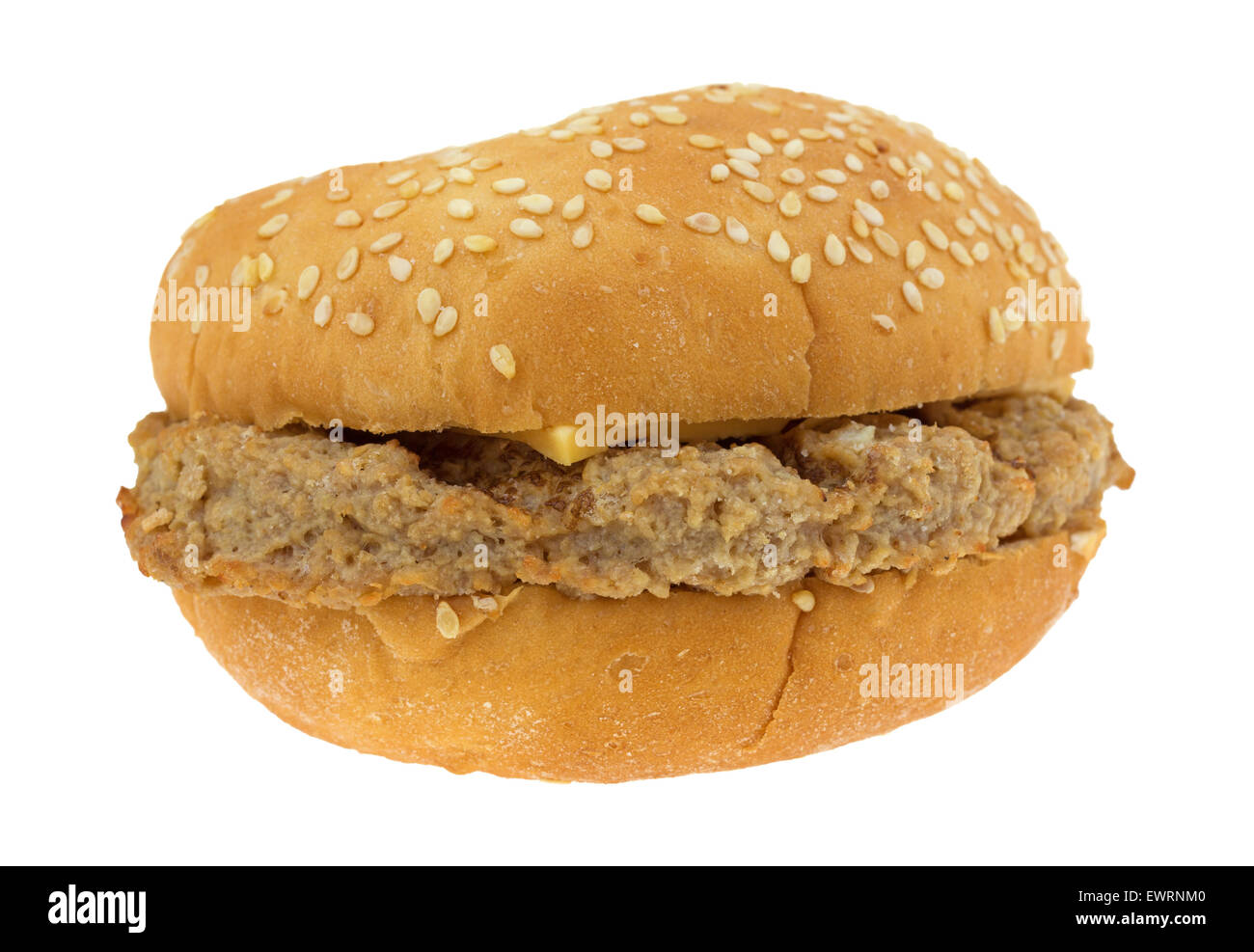 A microwaved cheeseburger with a sesame seed bun isolated on a white background. Stock Photo