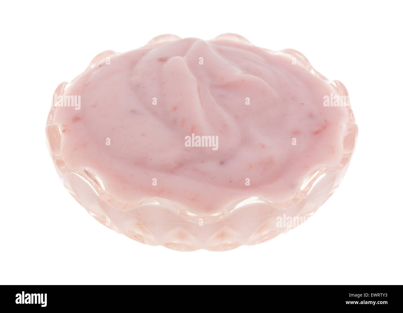 A small crystal glass bowl filled with a serving of strawberry yogurt on a white background. Stock Photo