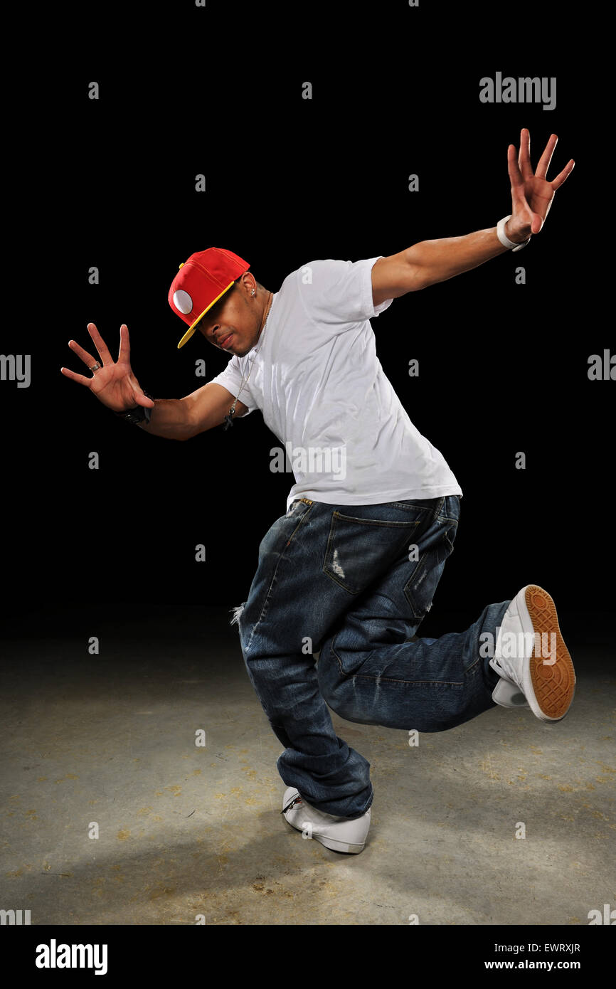 Young African American hip hop dancer performing over dark background Stock Photo