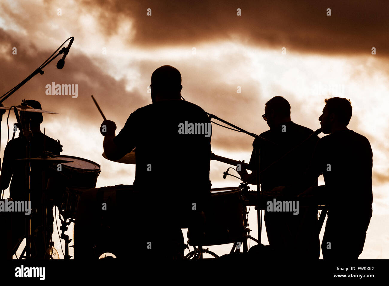 Band on stage at festival in silhouette at sunset Stock Photo