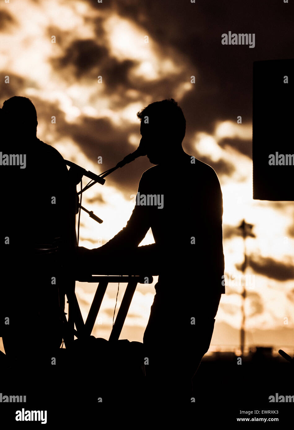 Band on stage at festival in silhouette at sunset Stock Photo