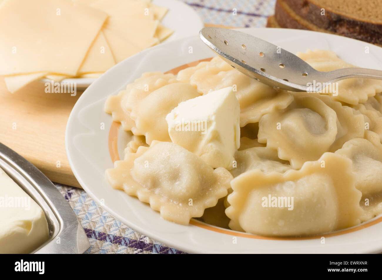 hot lunch with boiled a dumplings in an environment of bread of cheese and oil Stock Photo