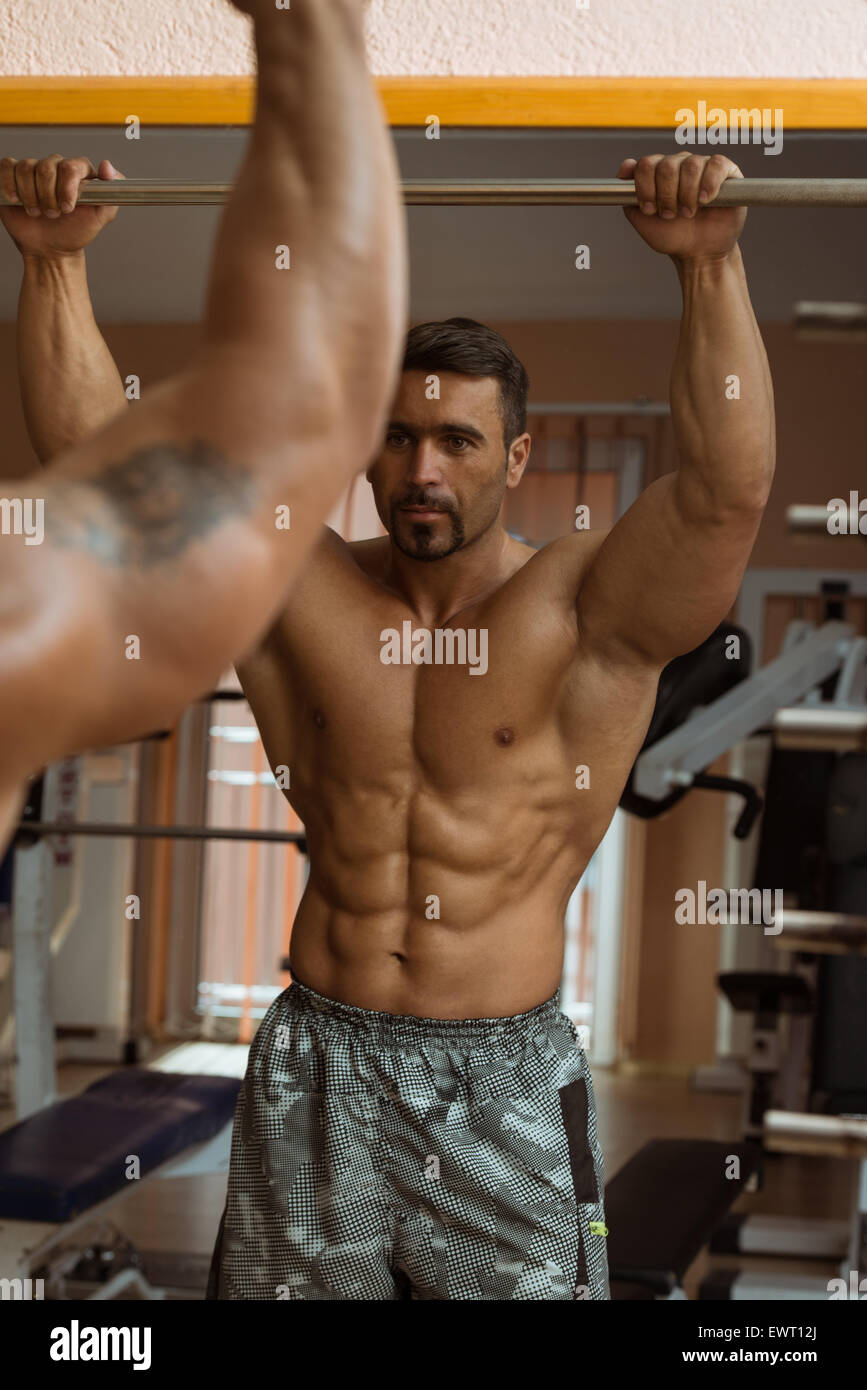 https://c8.alamy.com/comp/EWT12J/muscular-man-flexing-abdominal-muscles-abs-in-a-health-club-EWT12J.jpg