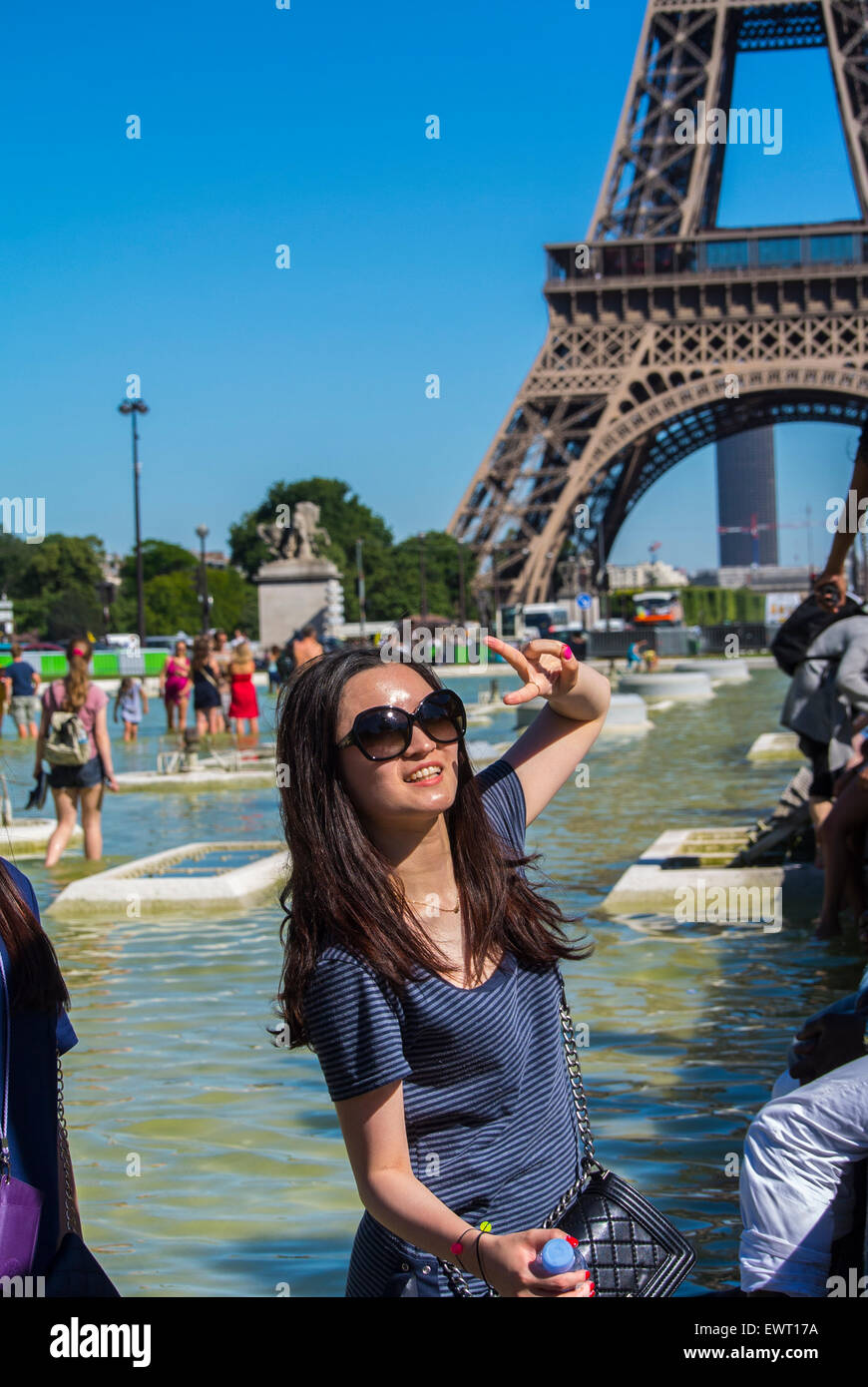 Paris, France. People Enjoying Summer Urban Heat Wave, at Eiffel Tower Pool, Chinese tourists Posing for Photos, Sunny Day, teens on hot day, [Teenager] Stock Photo