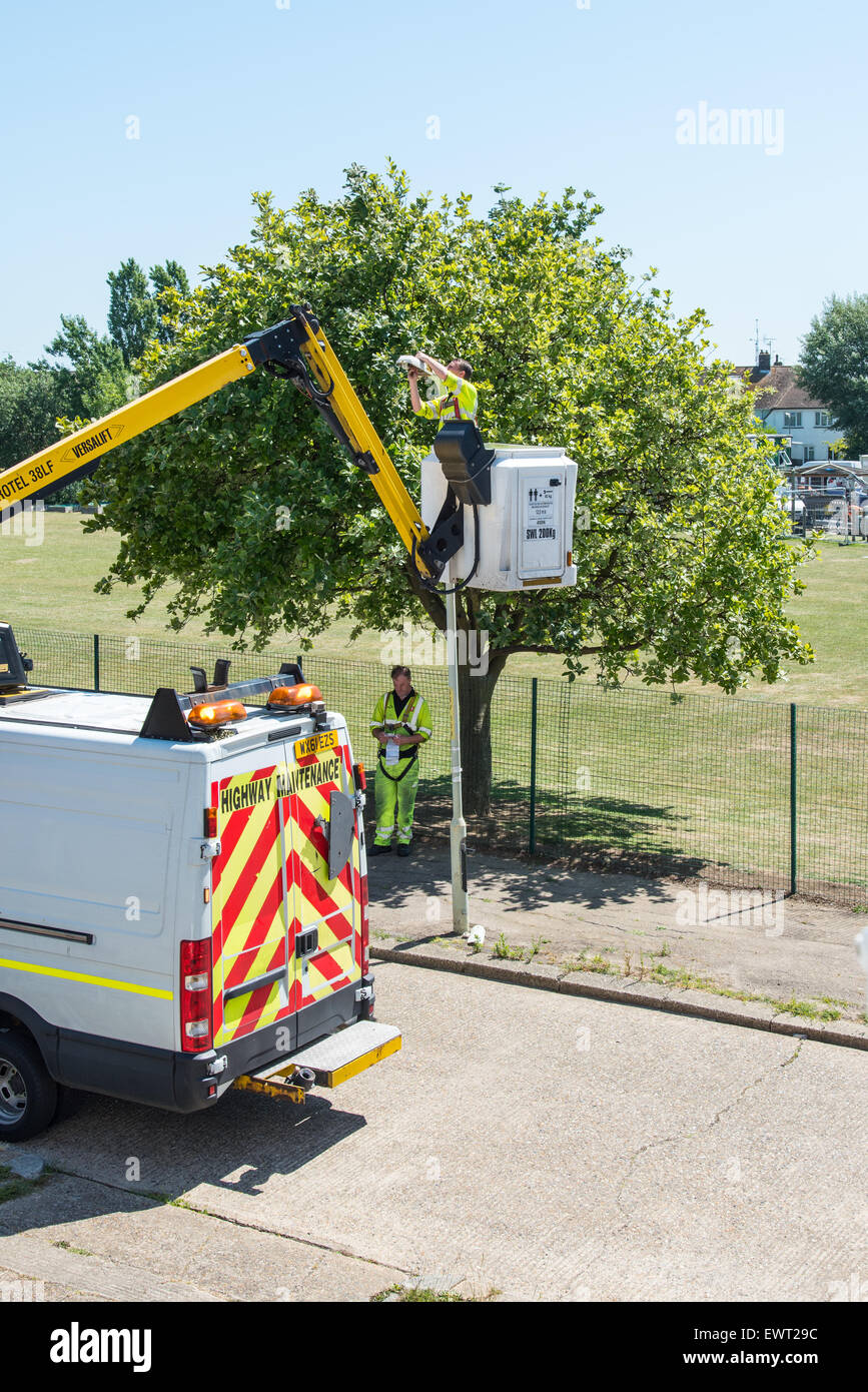 Cherry picker being used for traffic light maintenance in suburban street Stock Photo Alamy