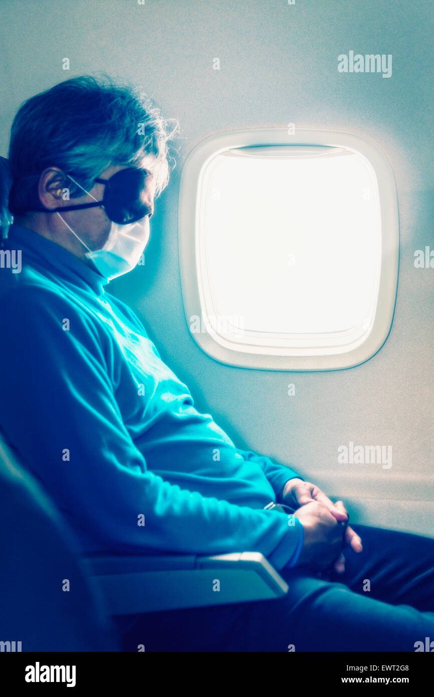 Man sleeping on airplane with  eye mask and mask on mouth Stock Photo