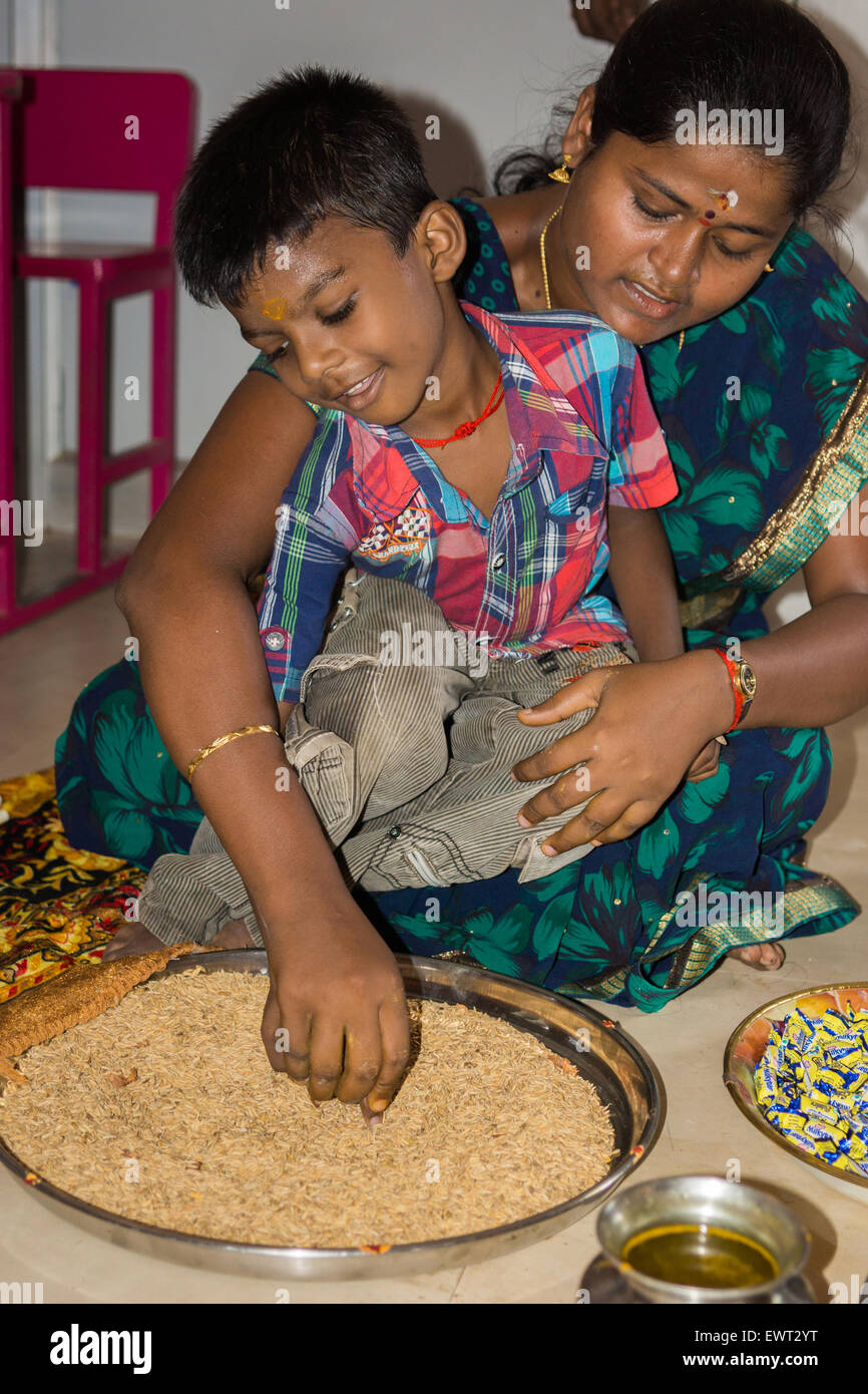 Vijayadasam ceremony: boy writes A in grain. Stock Photo