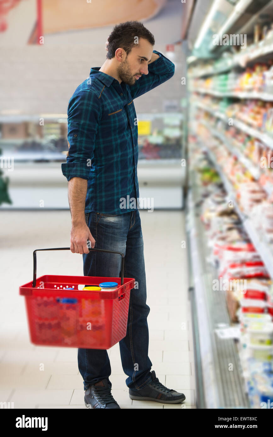 Handsome Young Man Shopping For Fruits And Vegetables In Produce Department Of A Grocery Store - Supermarket - Shallow Deep Of F Stock Photo
