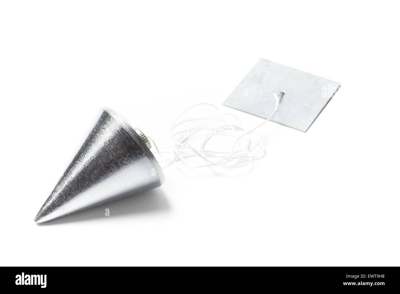 Metal plummet in the form of a cone white cord and plank. The objects are laid on the table and isolated on white. Stock Photo