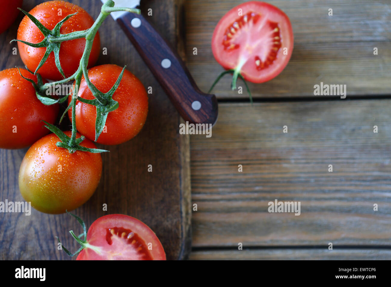 branch of red tomatoes on boards, rustic food Stock Photo - Alamy