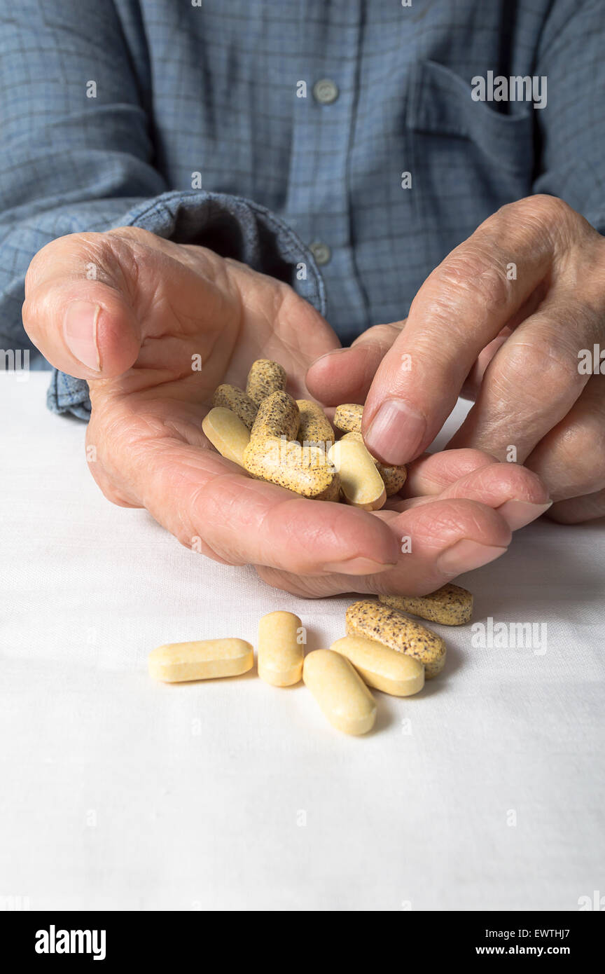 Senior hand sorting through a handful of medications. Selective focus ...