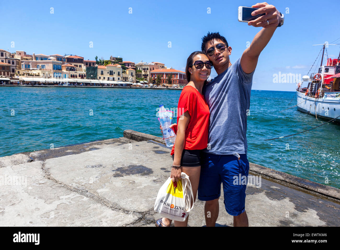 Tourists Taking Selfie on Smartphone Mobil Phone Snapshot Young Couple Happy People Man Woman Old Venetian Port Chania Crete Greece Europe Tourism Stock Photo
