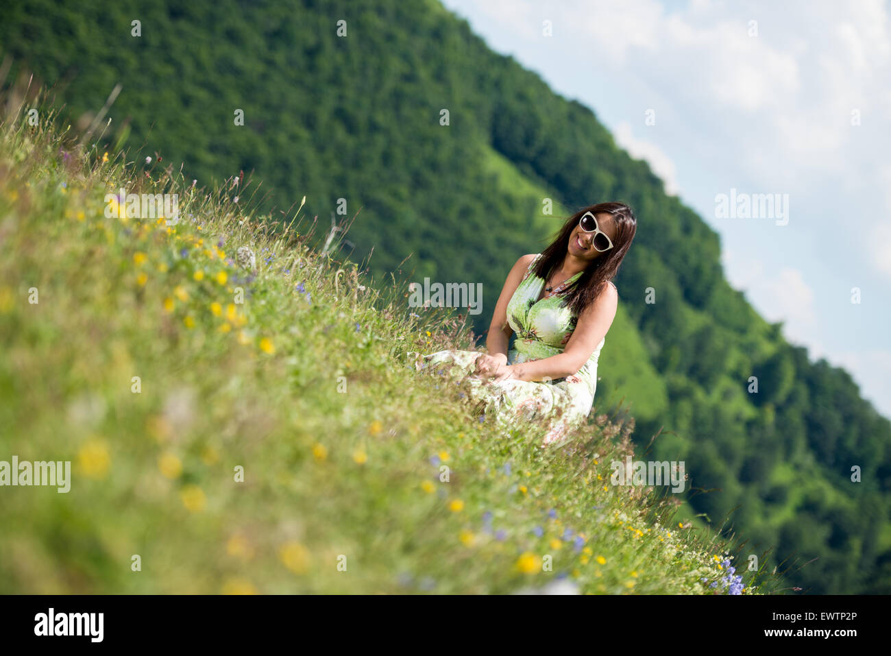 young woman in dress sitting on the grass Stock Photo - Alamy