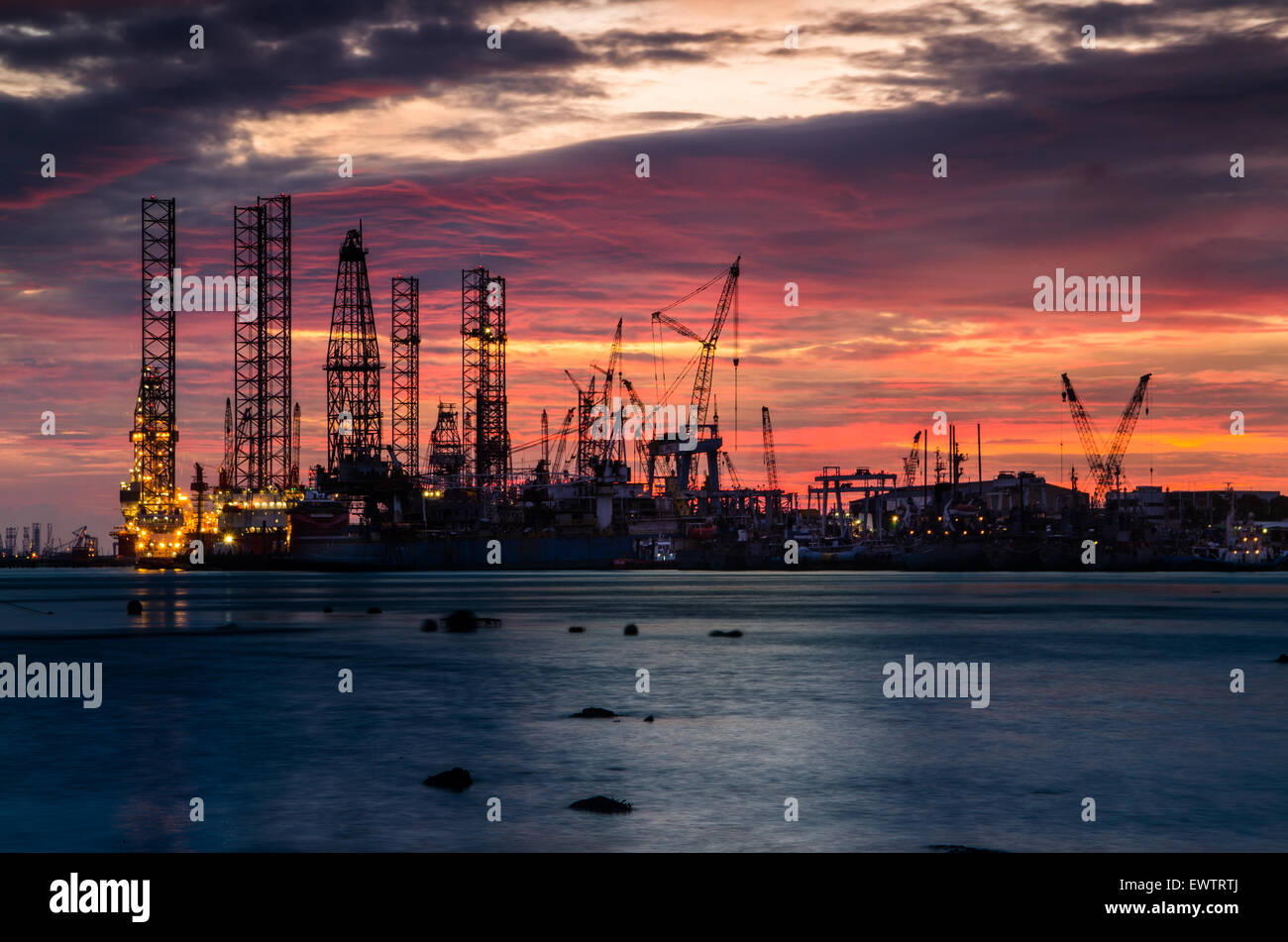 Beautiful Sunset with offshore platform. Low oil price had hit the industrial hard, left behind stranded drilling platform unable to bring on field. Stock Photo