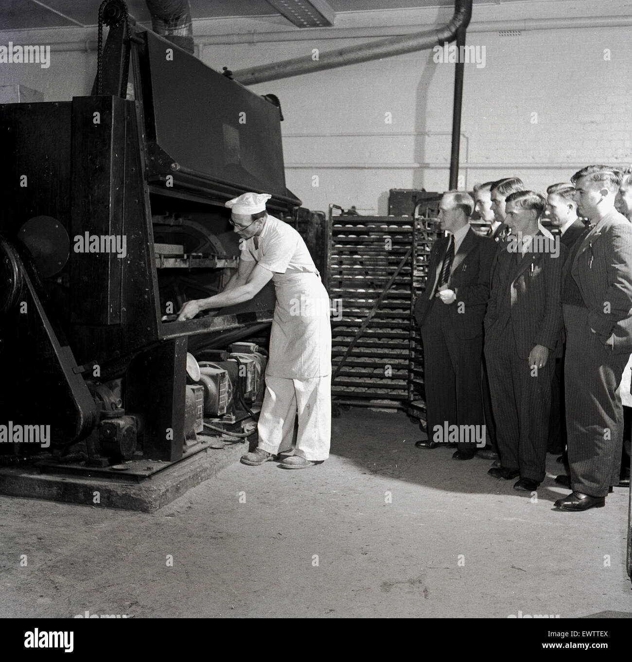 historical, 1950s, male chef showing group of adult men a large industrial sized bread oven. Stock Photo