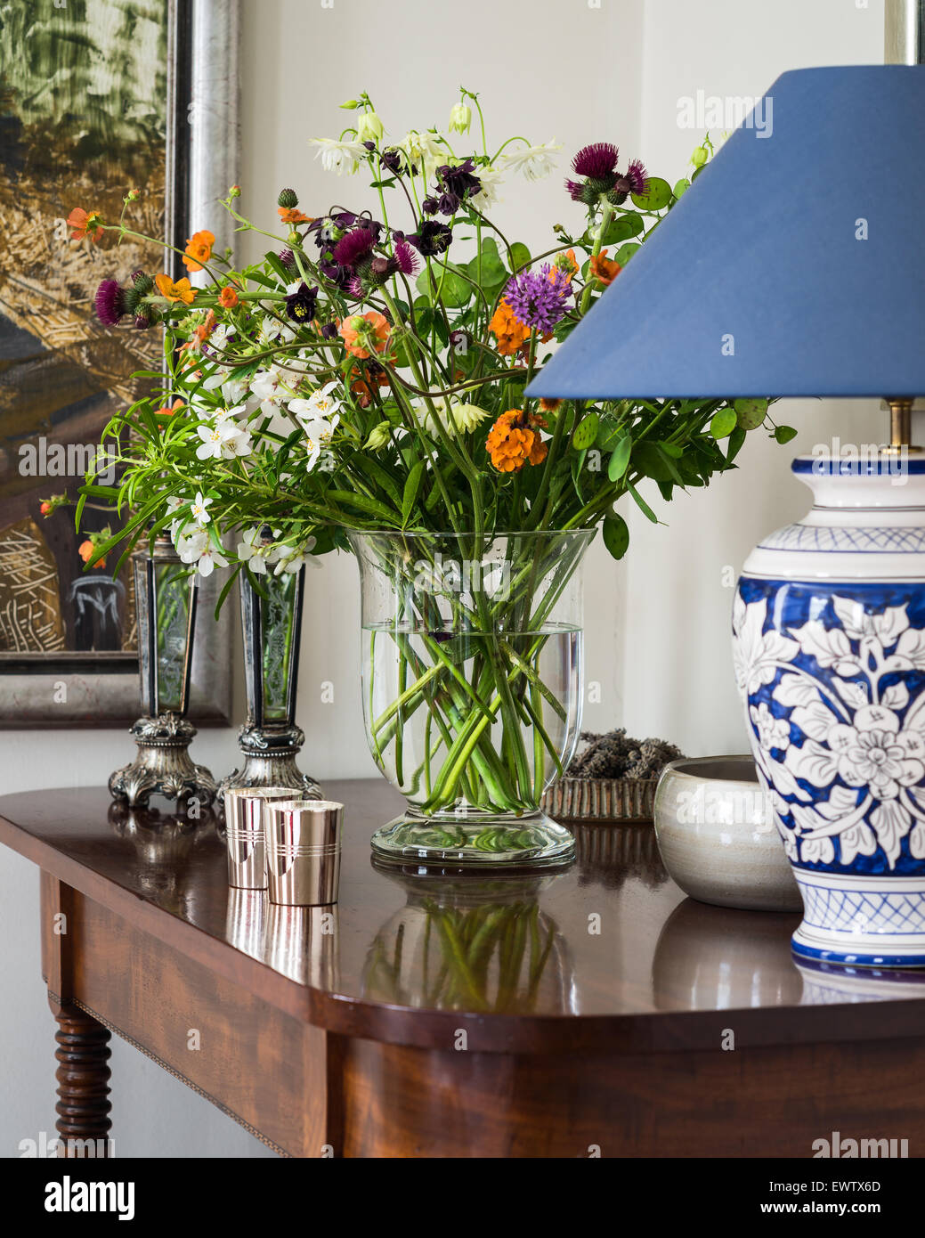 Chinese style lamp base pm antique mahogany table with vase of wild flowers Stock Photo