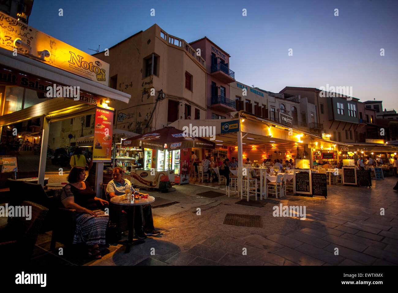 Old Venetian harbour of Chania bar cafe Crete, Greek Islands, Greece dusk waterfront Stock Photo