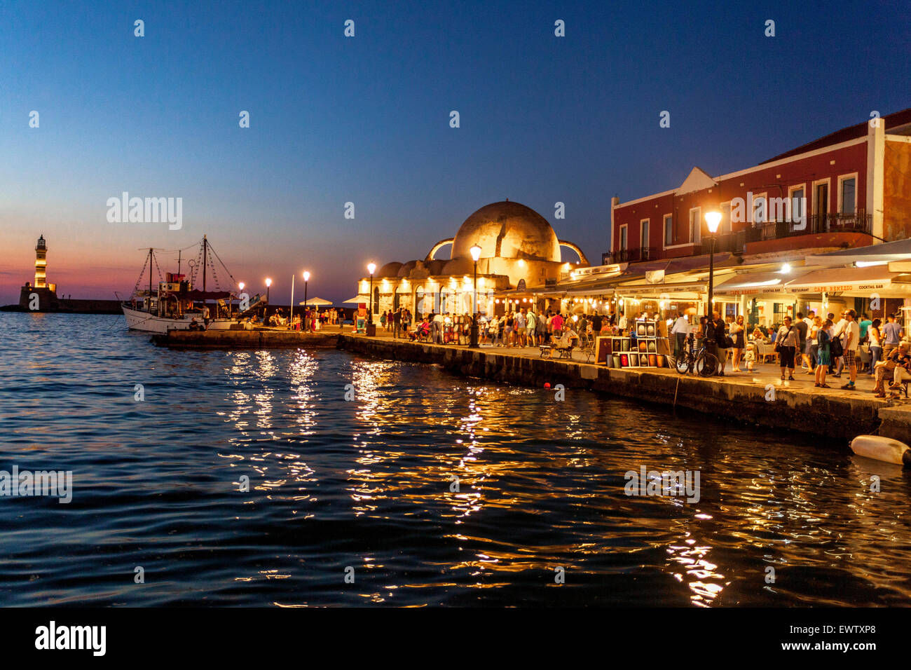 Evening lights of waterfront bars Chania Harbour Crete Venetian harbour Greece sunset Stock Photo