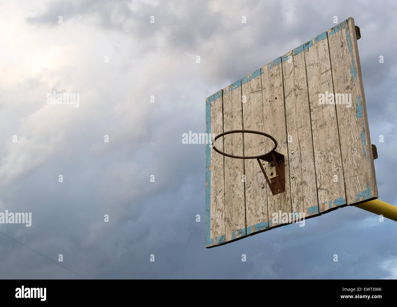 Old fading basketball net and board with a grey doom filled dark sky