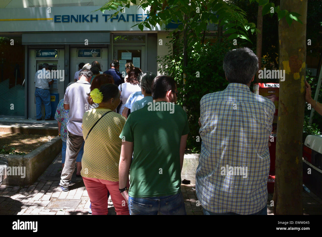 Line of people waiting to withdraw cash from ATM. Banks are closed in Greece and daily limit capital controls are implemented. Stock Photo